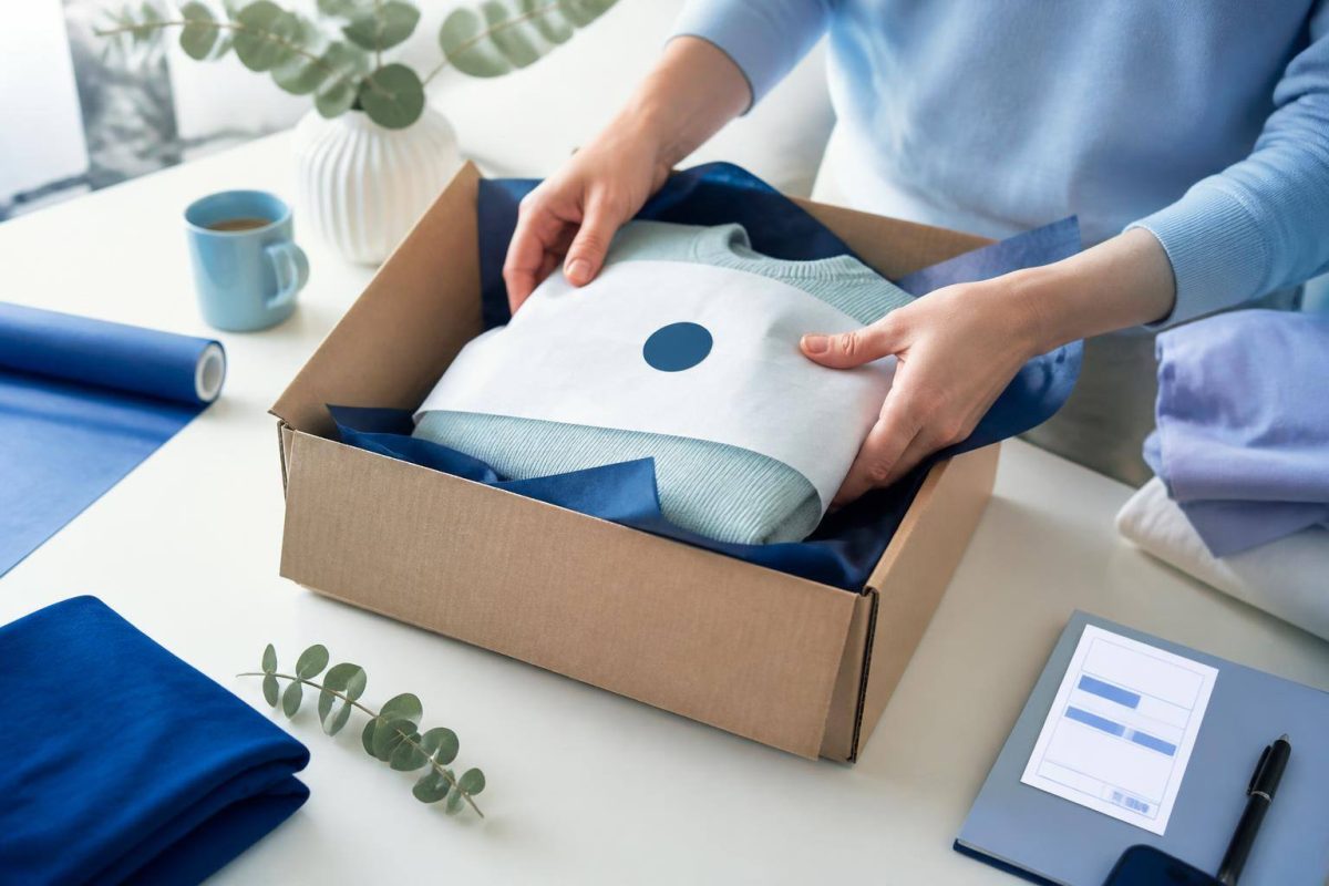 Paquete de ecommerce junto a una caja abierta, etiqueta de devolución y elementos de atención al cliente